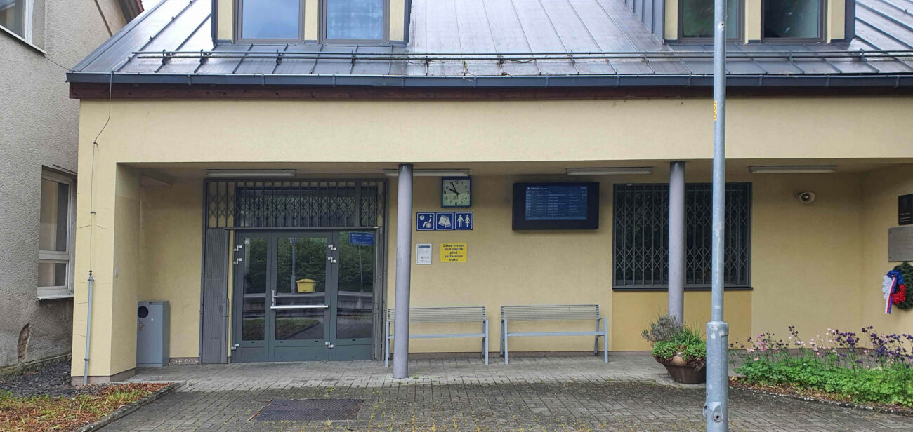 Pamětní deska je na verandě, jak se chodí do čekárny, vpravo na stěně